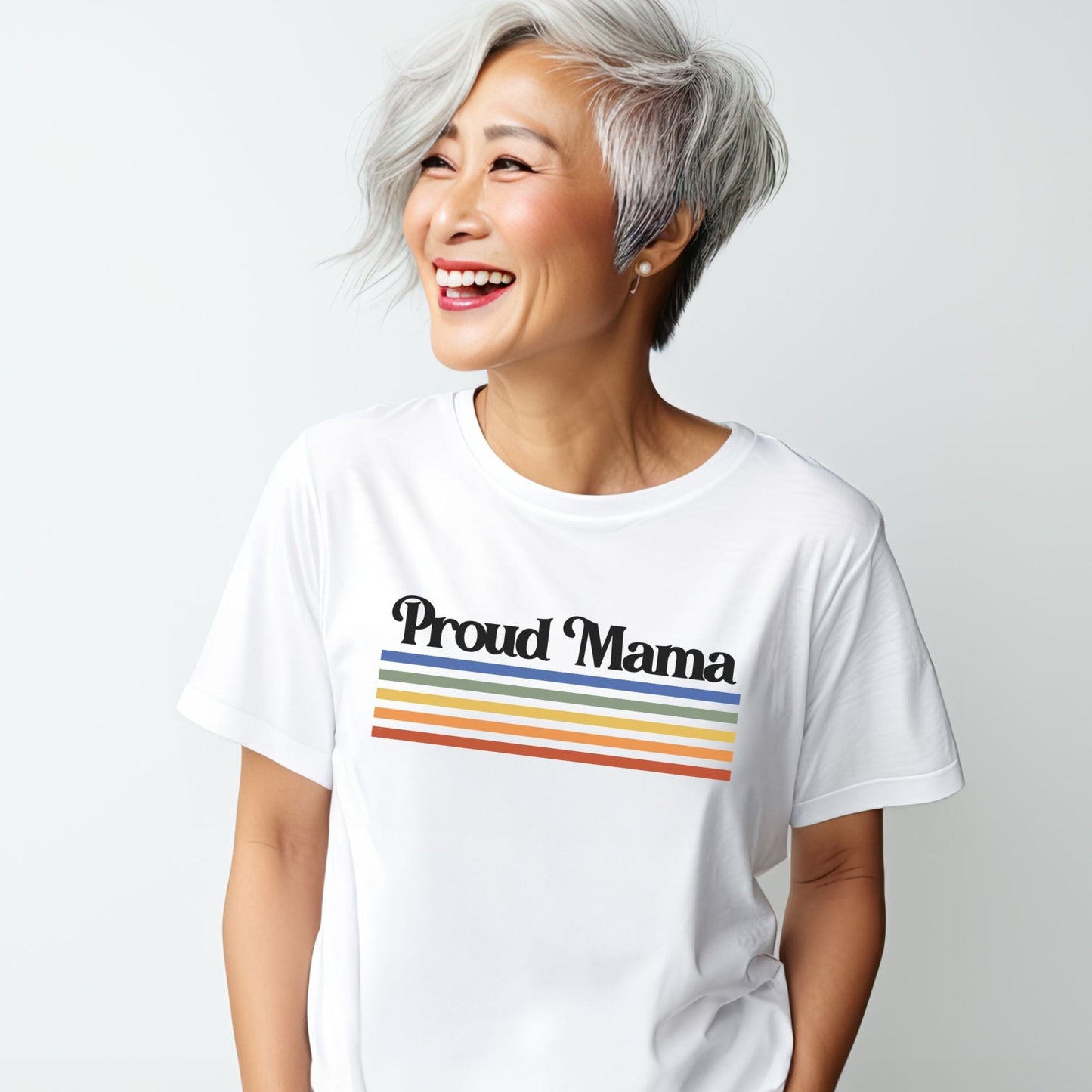 Asian woman smiling while wearing a white “Proud Mama” rainbow t-shirt.