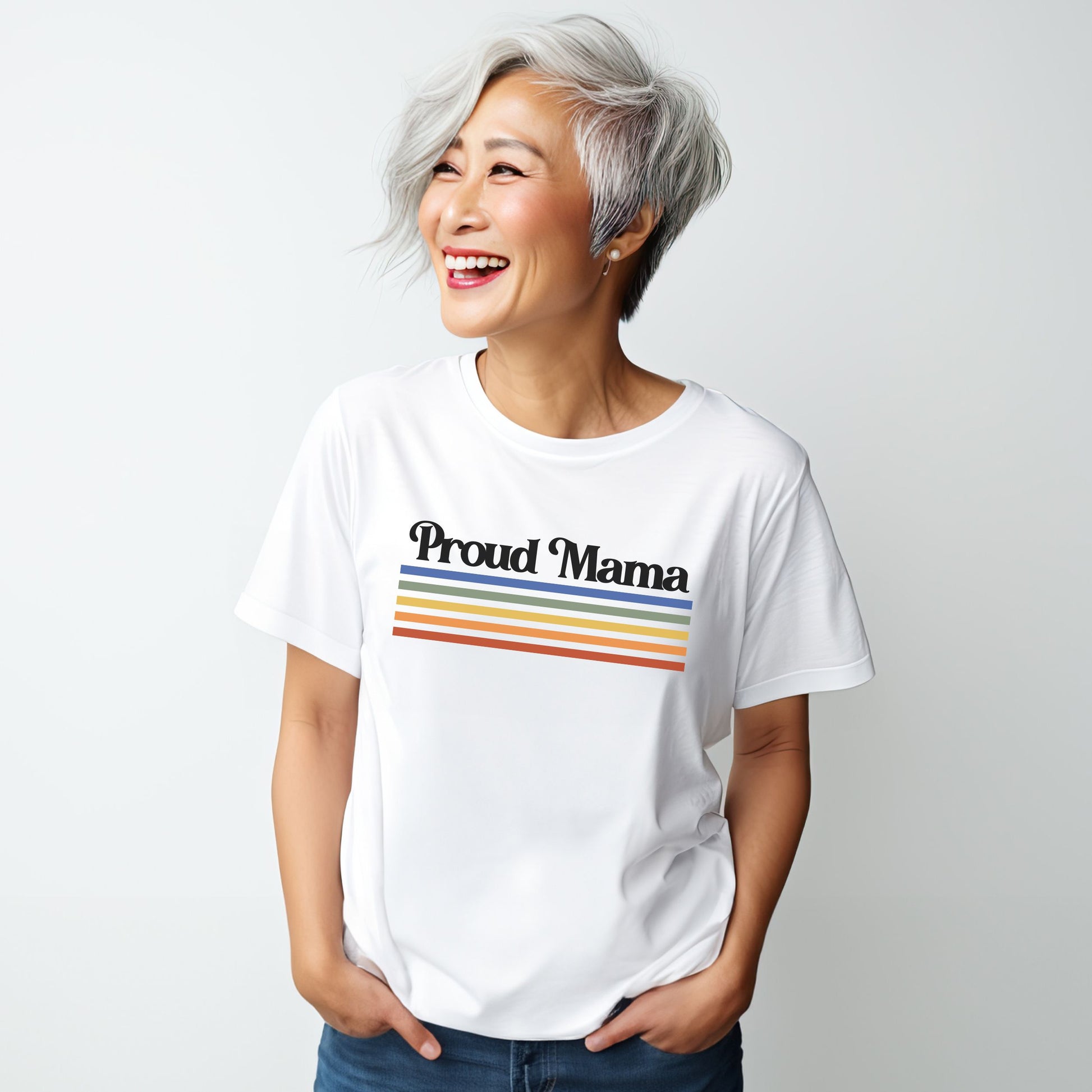 Asian woman smiling while wearing a white “Proud Mama” rainbow t-shirt.